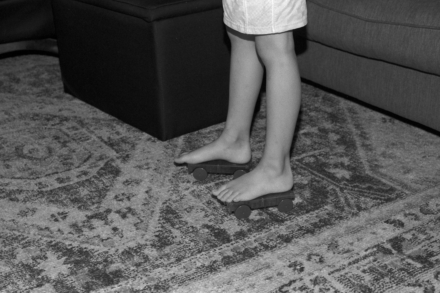 black and white photo of my 8 year old child's legs on magna tile skates